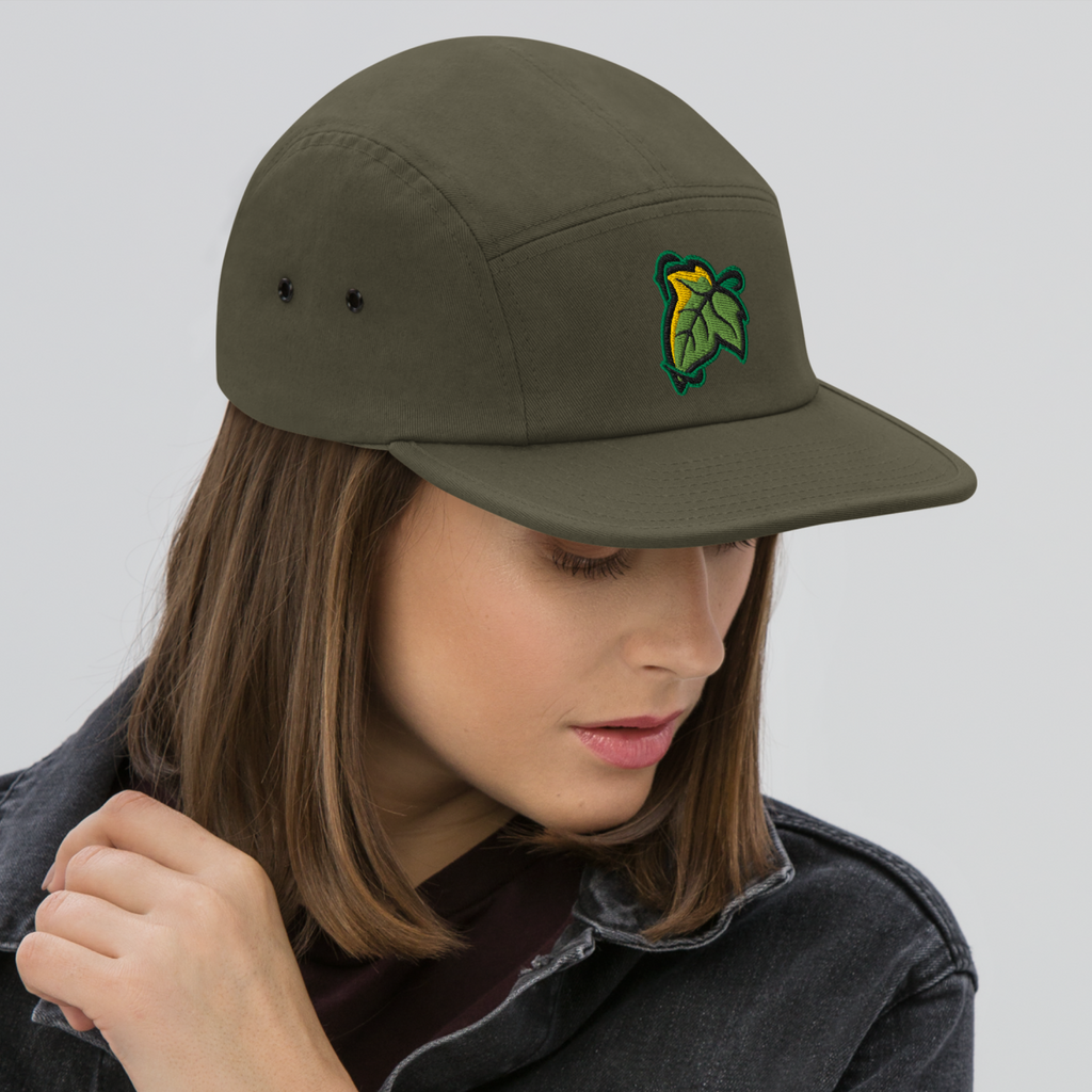 Model wearing an olive Elven Brooch cap with a green and gold leaf on the front.